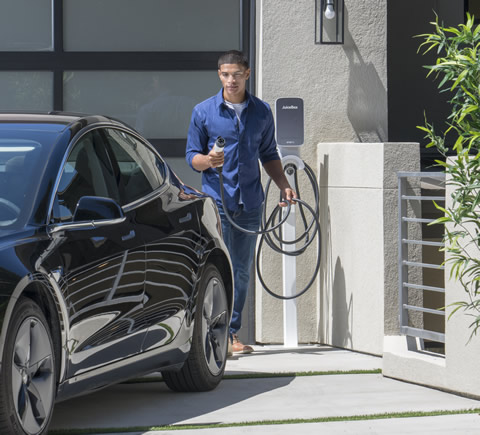 man charging a black EV from the electric vehicle fleet company